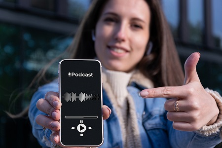 Image of a woman pointing to a podcast playing on her mobile phone