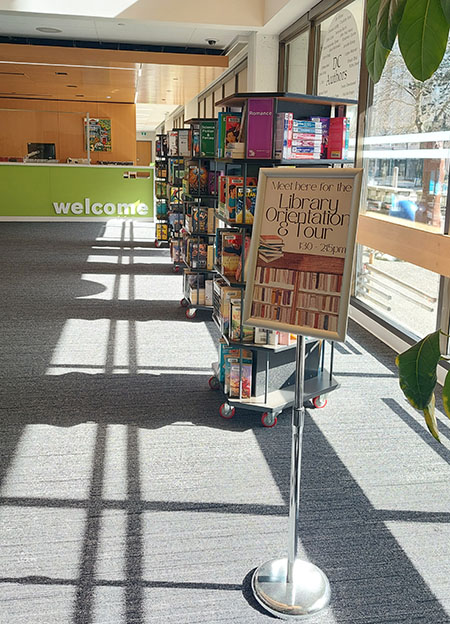 Image of sign in library showing the meeting spot for a library orientation