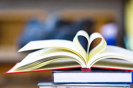 Decorative photo of a pile of books in the shape of a heart.